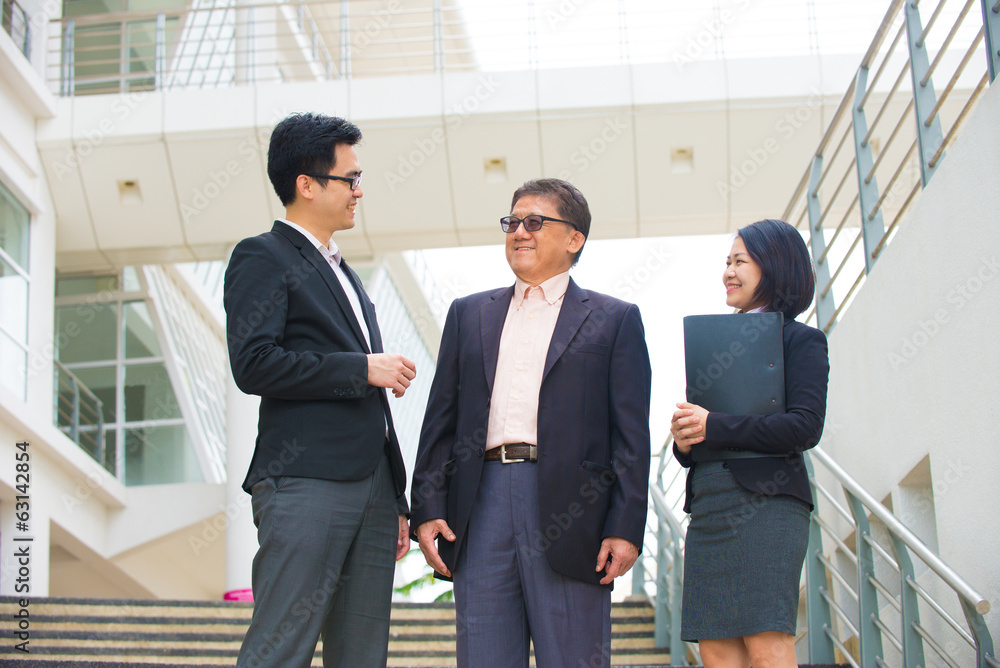 asian business team in conversation with office background asian business team in conversation with office background