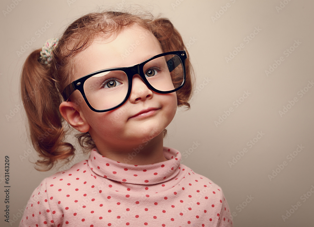 Dreaming happy kid girl in glasses. Closeup instagram effect