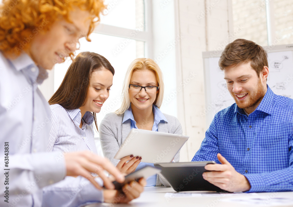 smiling team with table pc and papers working smiling team with table pc and papers working