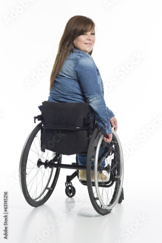 junge Frau im Rollstuhl von hinten