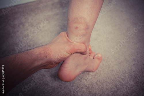 Man grabbing woman's bruised leg