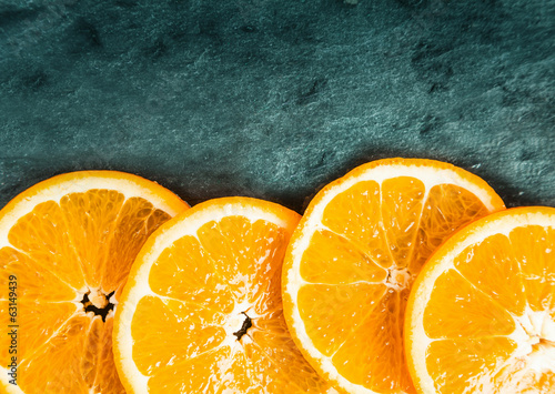 Colorful orange slices on textured slate photo