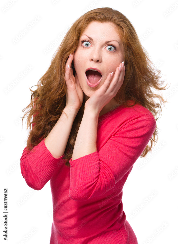 Woman is holding her face in astonishment Woman is holding her face in astonishment