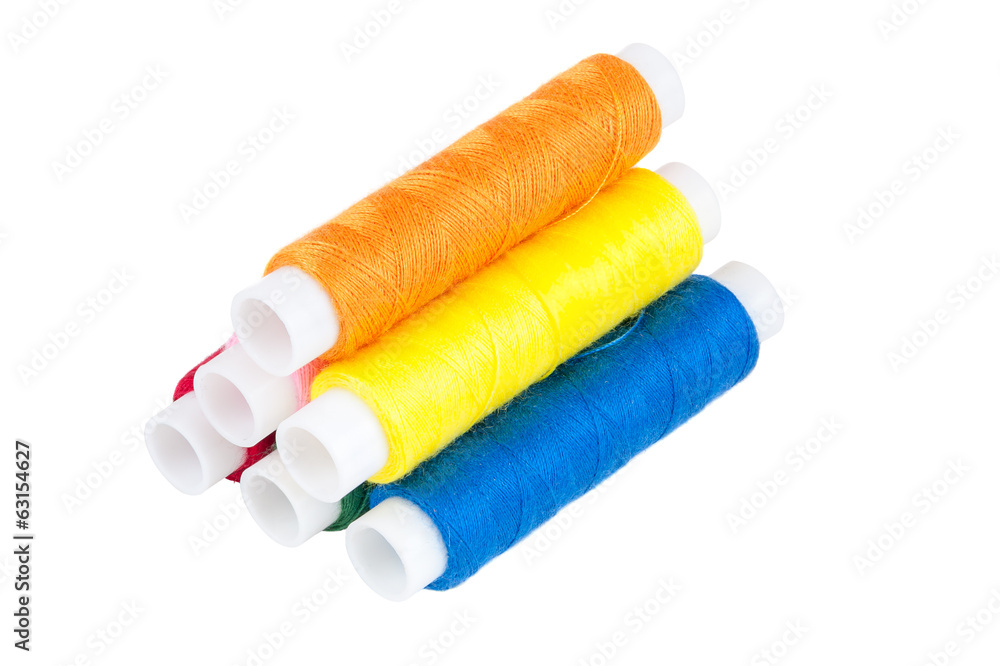 Colored spools of threads on white background Colored spools of threads on white background