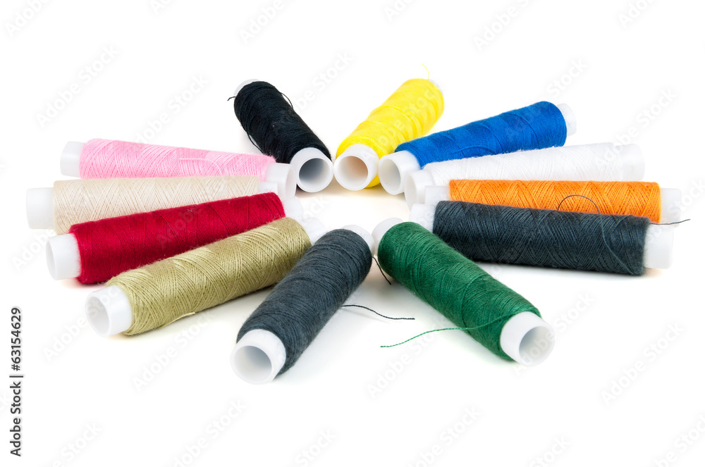 Colored spools of threads on white background Colored spools of threads on white background