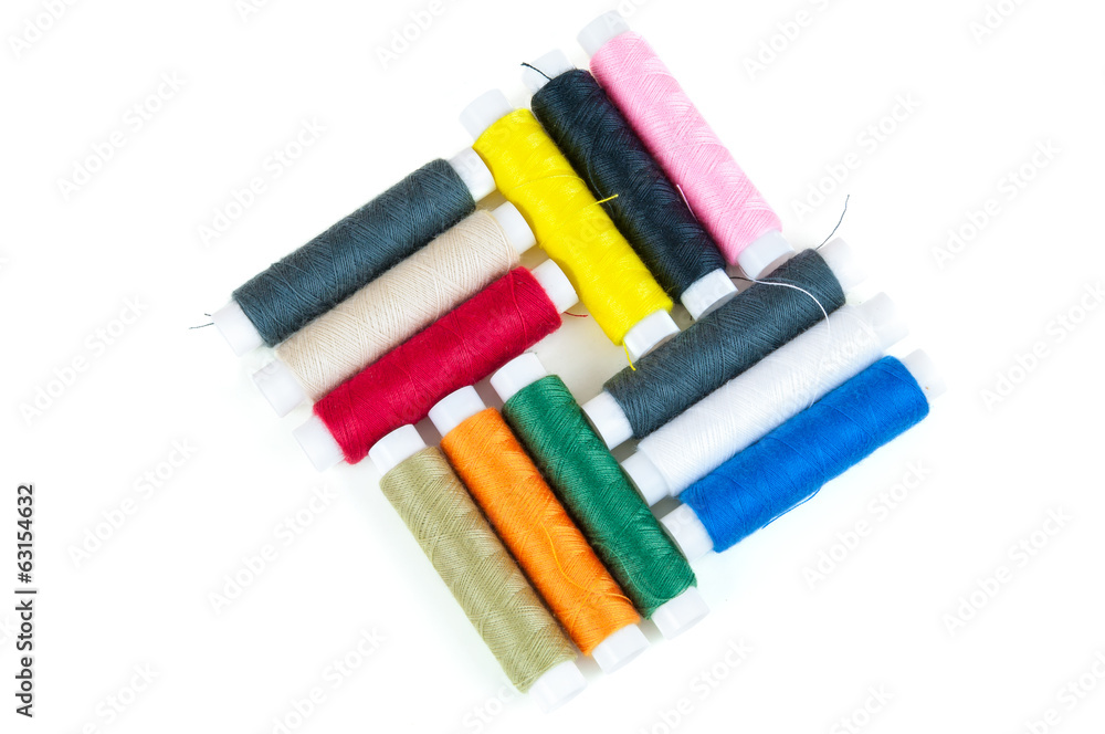 Colored spools of threads on white background Colored spools of threads on white background