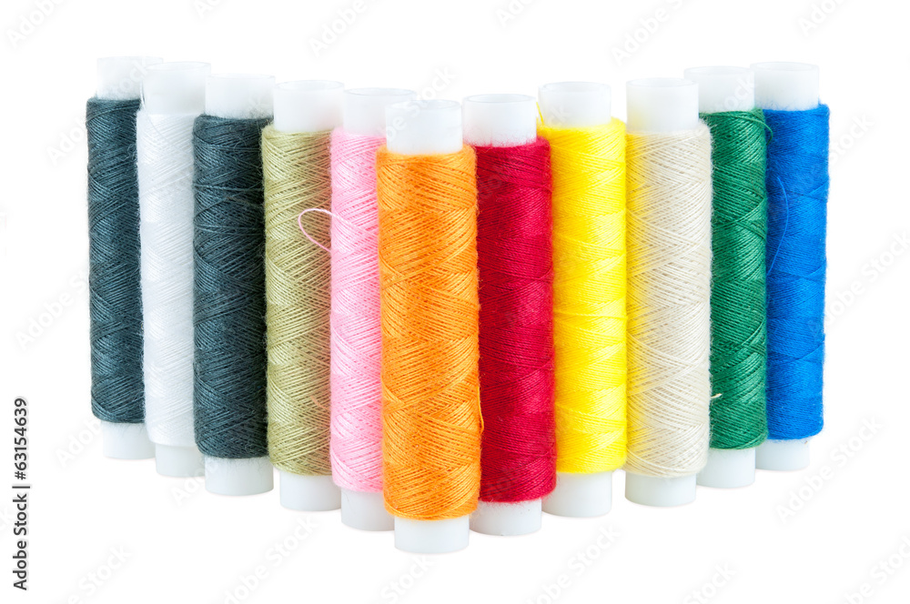 Colored spools of threads on white background Colored spools of threads on white background