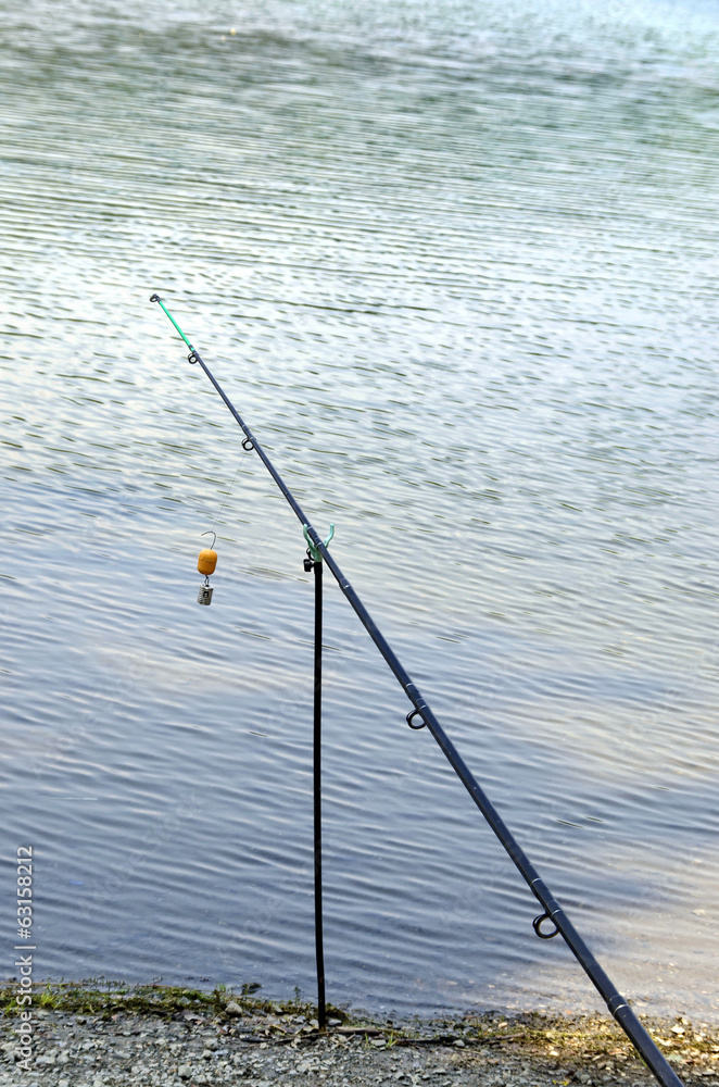 A long fishing rod standing on a beach