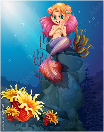 A smiling mermaid sitting above the rocks
