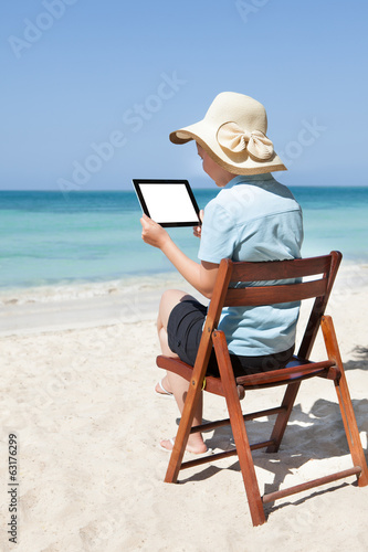 Woman Using Digital Tablet At Beach