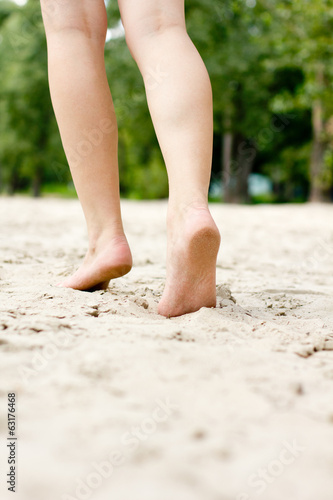 Female legs on a beach background © 0635925410