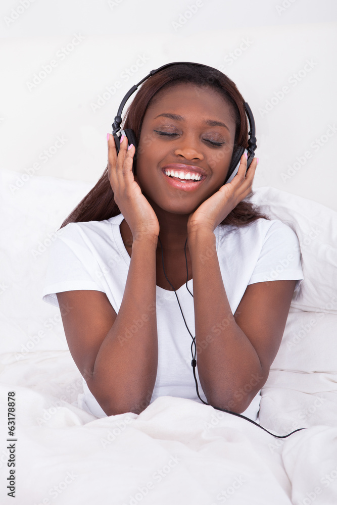 Happy African American woman enjoying music through headphones Happy African American woman enjoying music through headphones