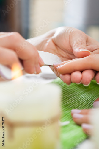 Beautician Filing Nails Of Woman