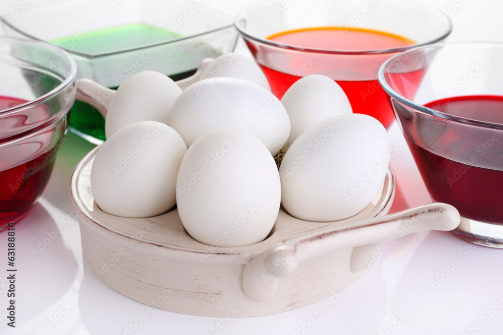 Eggs with liquid colour in glass bowls close up Eggs with liquid colour in glass bowls close up