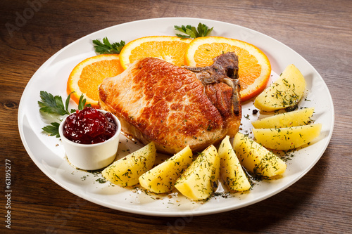 Foto Grilled steak, boiled potatoes and lingonberry jam