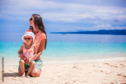 Adorable little girl and her mother on the white sandy beach © travnikovstudio