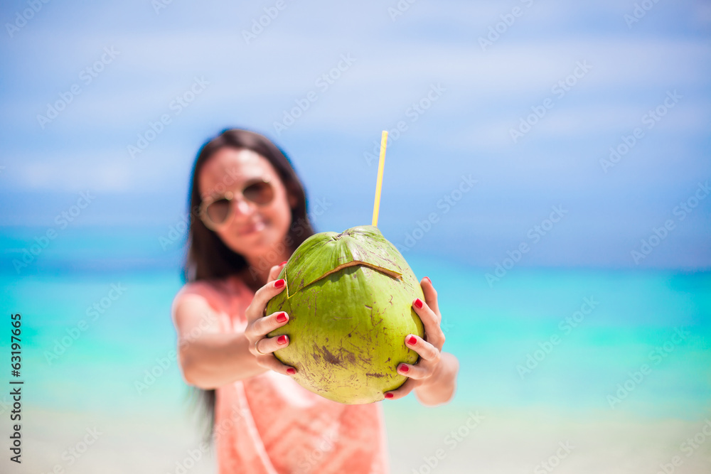 Fototapeta premium Closeup a coconut in hands of young girl