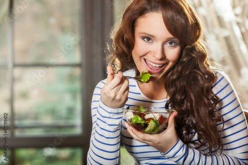Woman eating fresh vegetable salad