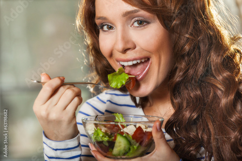 Woman eating fresh vegetable salad