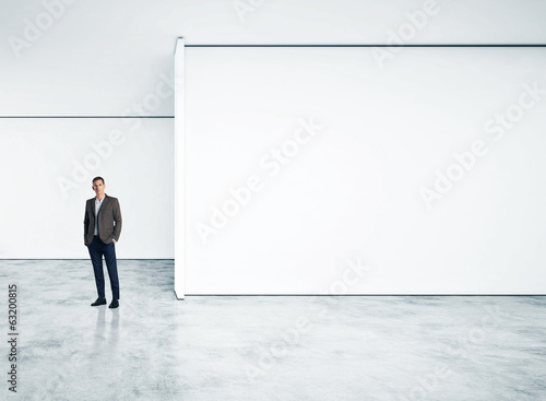Businessman standing in empty bright office © SFIO CRACHO