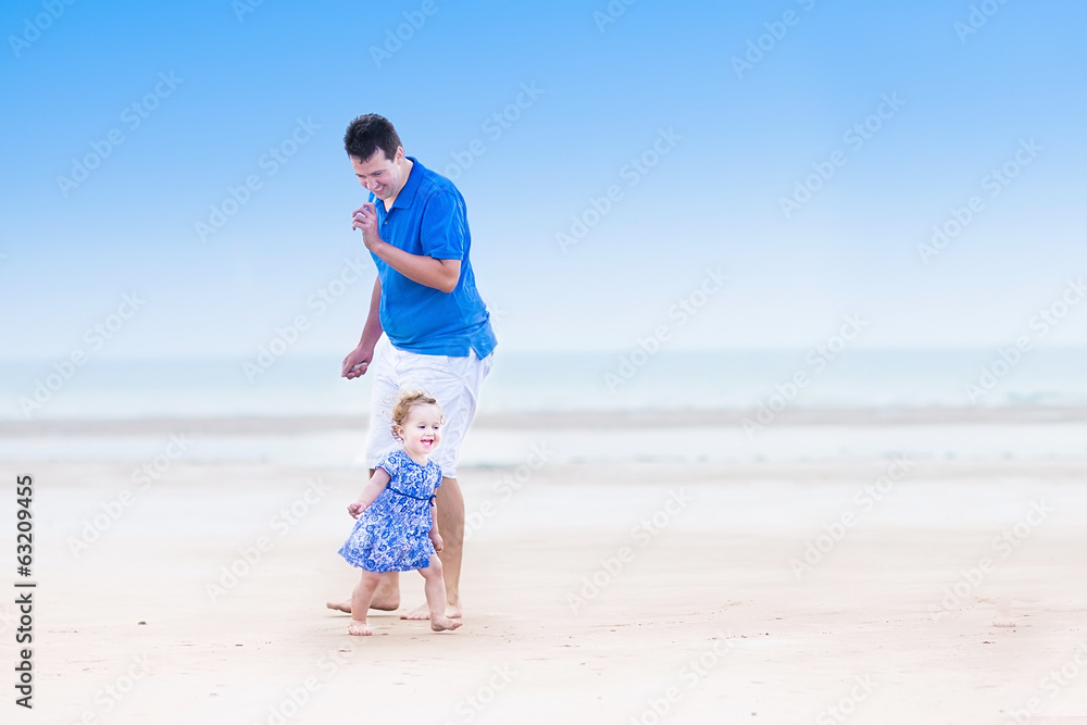 Young father playing with his cute toddler daughter on a beach Young father playing with his cute toddler daughter on a beach