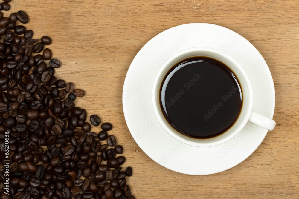 Coffee cup on old wooden table with beans Coffee cup on old wooden table with beans