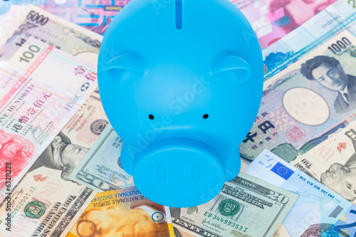 Blue piggy bank on international banknote background