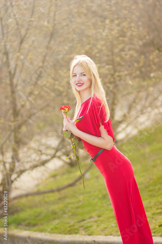 Fototapeta Naklejka Na Ścianę i Meble -  portrait of blond woman in red maxi dress