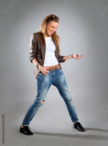 Woman listening to music on mp3 player, dancing playing air guit