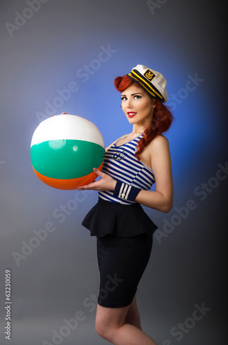 Pin up girl playing with a beach ball