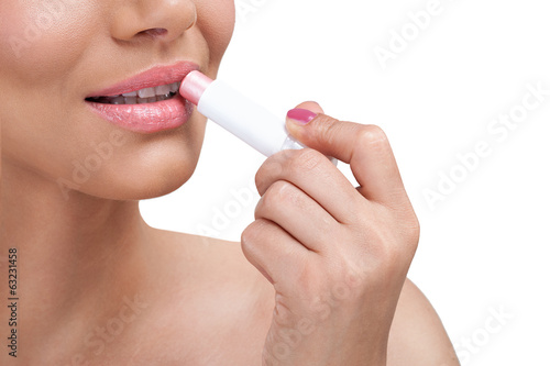 Beautiful woman  applying balsam for lips