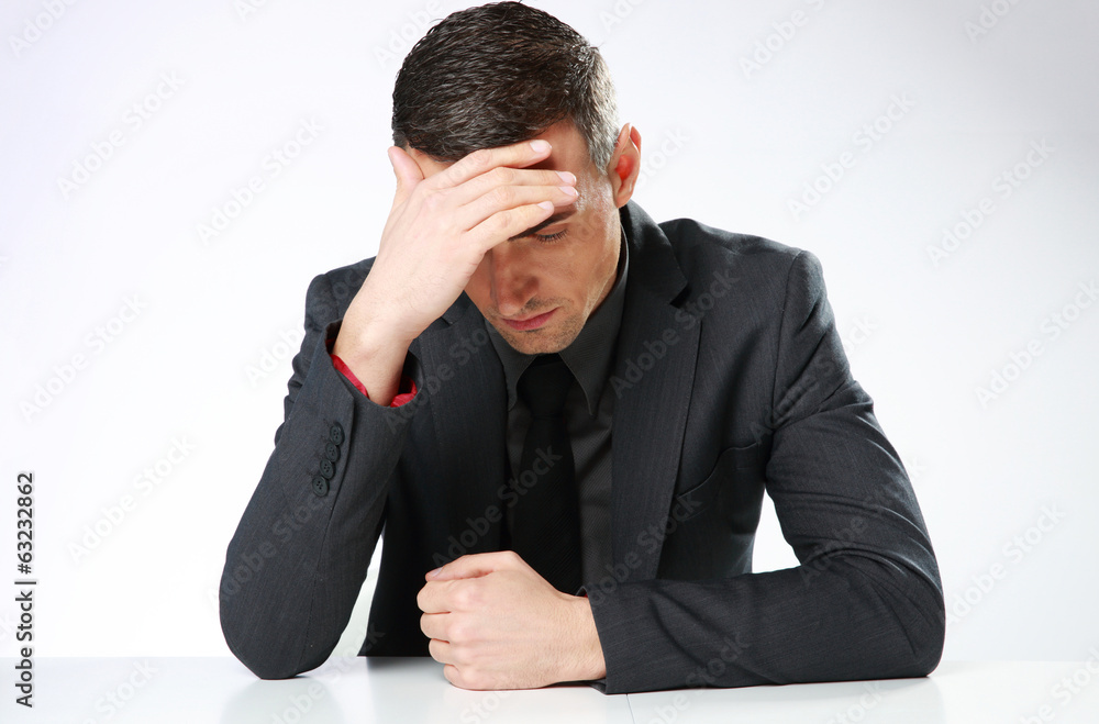 Depressed businessman sitting at the table Depressed businessman sitting at the table