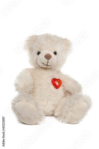 Fluffy white teddy bear with a heart on white