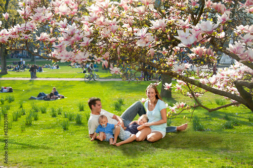 Familie im Park unter einem Magnolienbaum