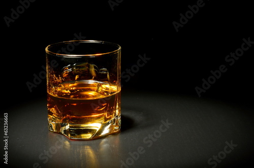 Glass of whiskey on black table