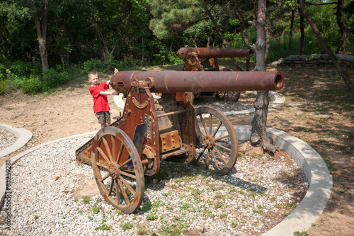 Boy at the old cannon on wheels