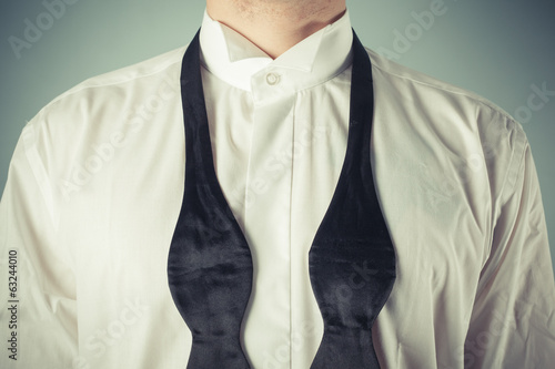 Obraz na plátne Young man tying a bow tie