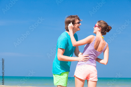 portrait of happy young couple in sunglasses in bright clothes © el.rudakova