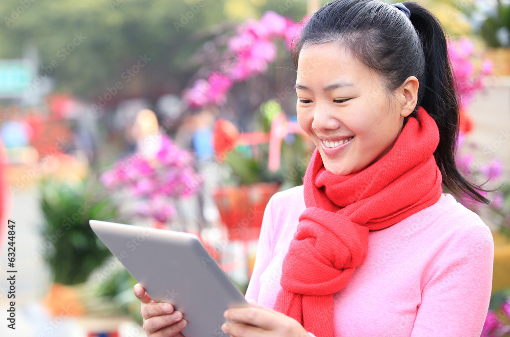 leisure young asian woman use digital tablet on flower street