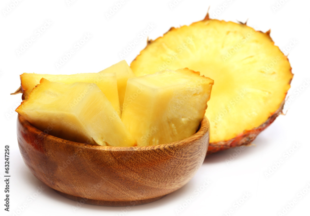 Sliced pineapple on a wooden bowl