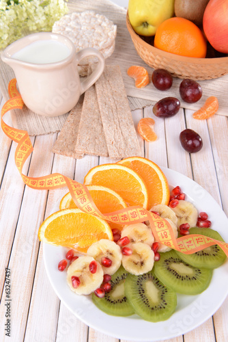 Sweet fresh fruits on plate on table close-up