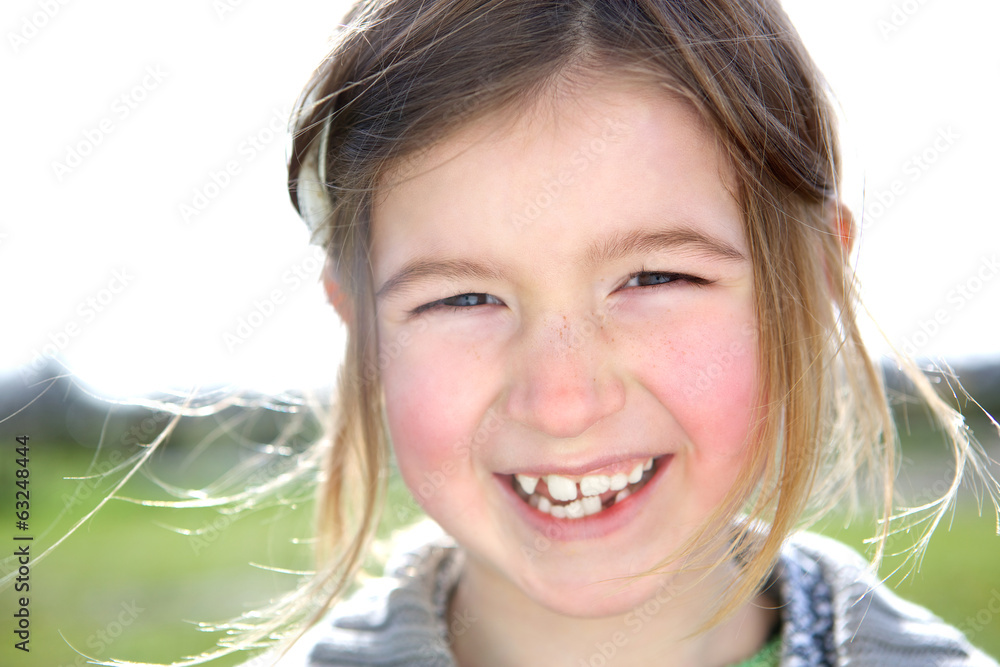 Cute young girl laughing outdoors Cute young girl laughing outdoors