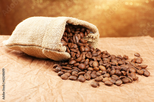 Coffee beans in sack on table close-up