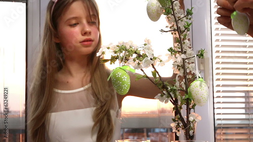 Happy family with child hang easter egg.