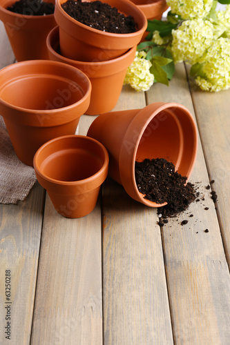 Clay flower pots and soil, on wooden table