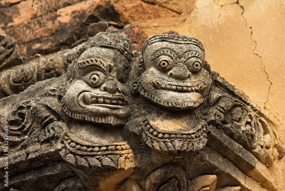 statue of two faces(full face) on the corner of ancient temple statue of two faces(full face) on the corner of ancient temple