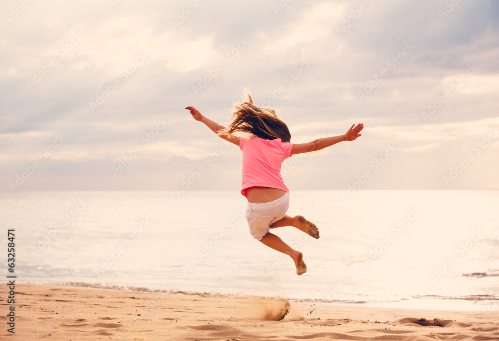 Happy Girl Jumping on the Beach at Sunset Happy Girl Jumping on the Beach at Sunset