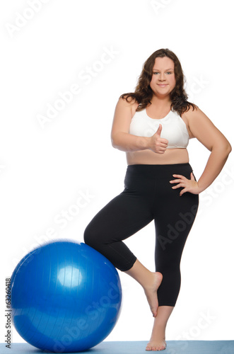 Happy woman with excess weight and ball