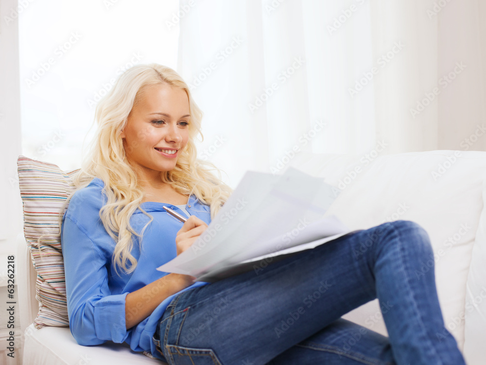 smiling young woman with papers at home smiling young woman with papers at home