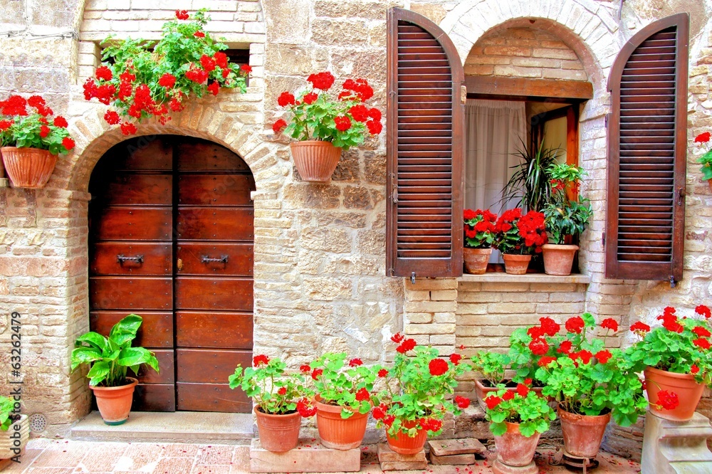 Naklejka premium Włoski dom przód z kolorowymi doniczkowymi kwiatami